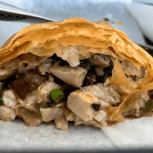 Chicken and mushroom filo parcel cut open to show the creamy filling inside flaky pastry